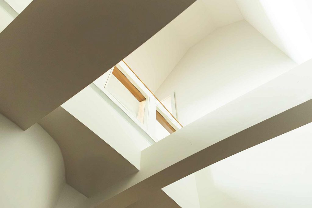 7I4A5137 Dachgeschoss-Innenraum mit geometrischer Kassettendecke, Oberlichtern und Holzbalken in minimalistischer Architektur